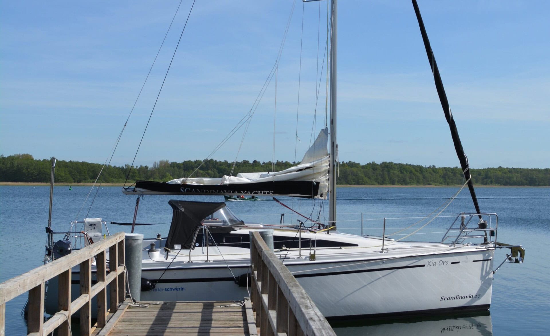 Segelboot am Holzsteg auf ruhigem See